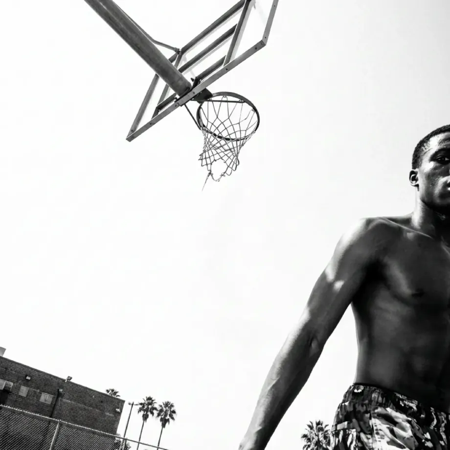 Black and white shot of a basketball player under the hoop