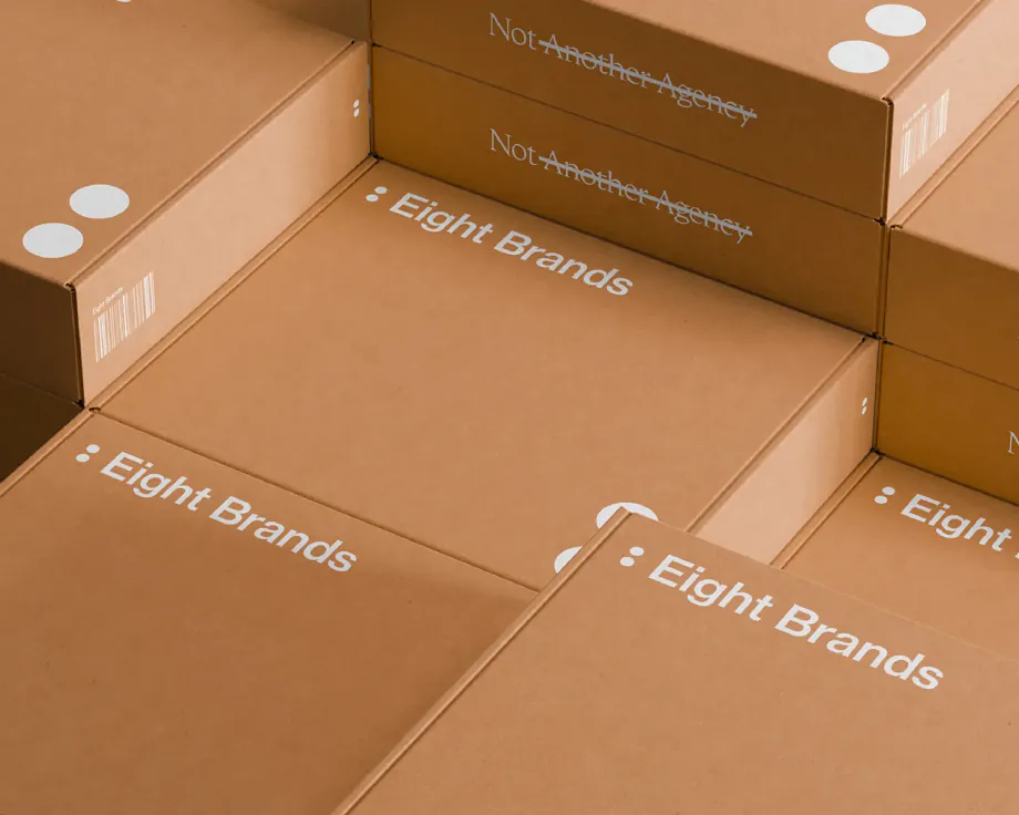 Stacked cardboard boxes printed with the Eight Brands logo