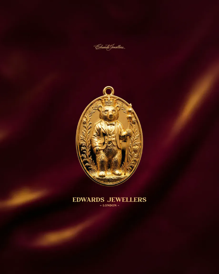 Gold Edwards Jewellers bear pendant on deep red silk
