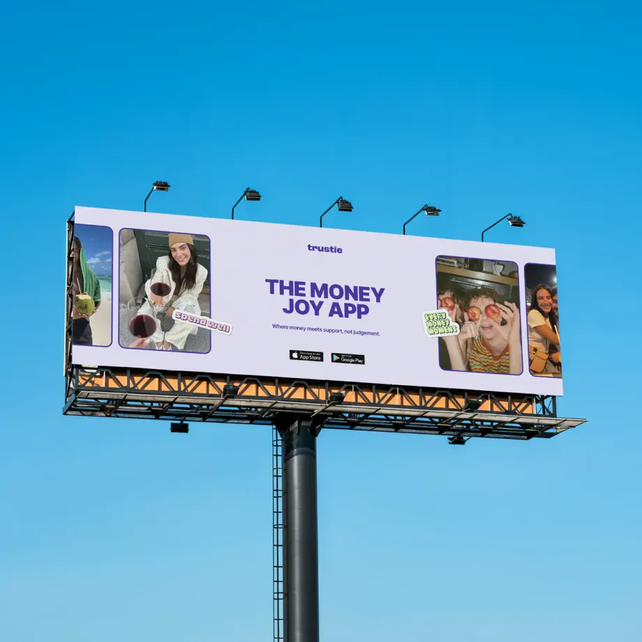 Trustie billboard reading The Money Joy App against a blue sky